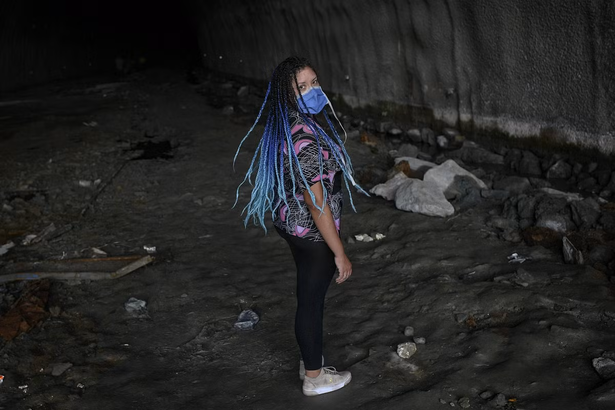 Người phụ nữ đeo khẩu trang khi đứng trong đường hầm phía dưới cao tốc ở Caracas ngày 7/6.