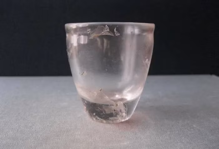 Trong số các bảo vật quý giá được tìm thấy, có một cái chén thủy tinh đeo dây chuyền vàng.