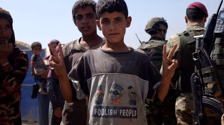 Một bé trai khác cũng làm cử chỉ như em bé phía trên.