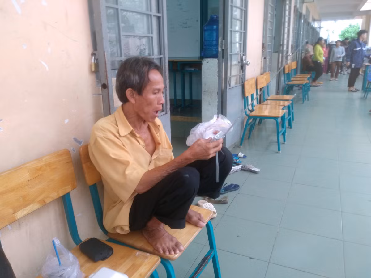 Người đàn ông vừa ăn bánh vừa nghe Radio để cập nhật tình hình về cơn bão số 9. 