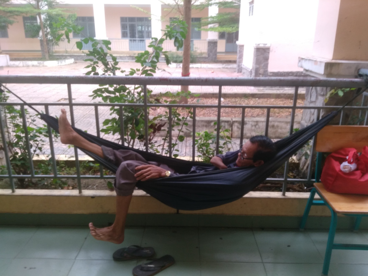 Một số người dân móc võng nghỉ ngơi bên ngoài hành lang. 