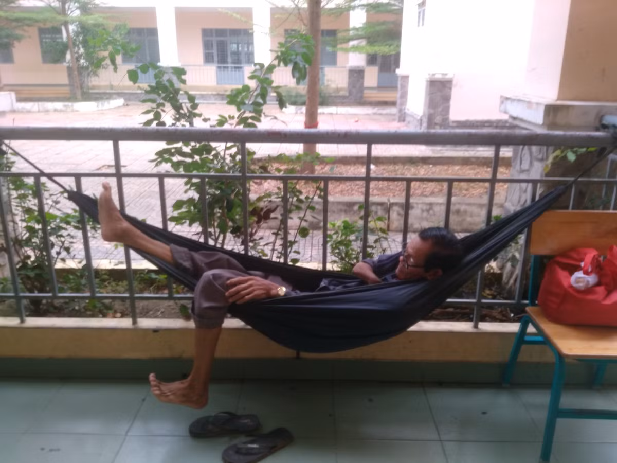 Một số người dân móc võng nghỉ ngơi bên ngoài hành lang. 