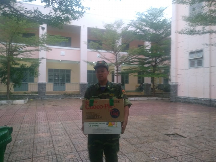 Các anh bộ đội đang bưng thức ăn để chuẩn bị cho bữa cơm tối cho người dân trước thềm con bão. 