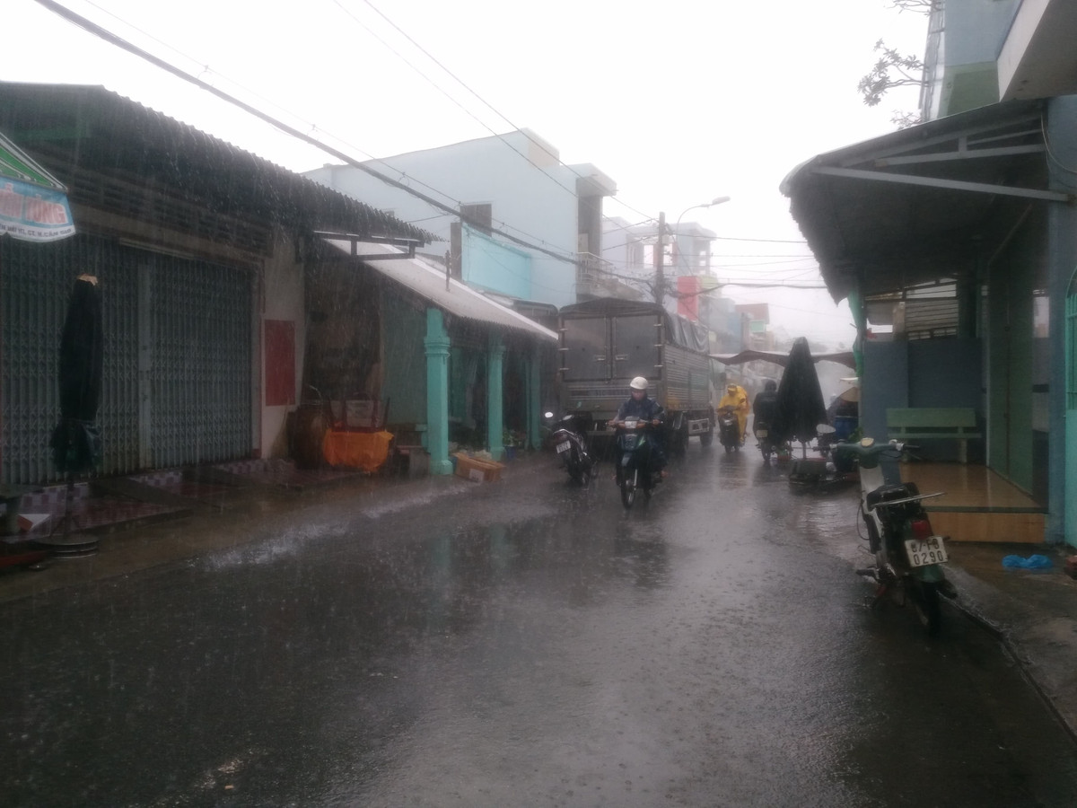 Trên các tuyến đường, người dân vẫn đi lại mặc kệ mưa to gió lớn có thể cuốn phăng mọi thứ bất cứ lúc nào. 