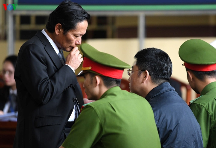 Các luật sư trao đổi với bị cáo trước khi phiên tòa tiếp diễn. 