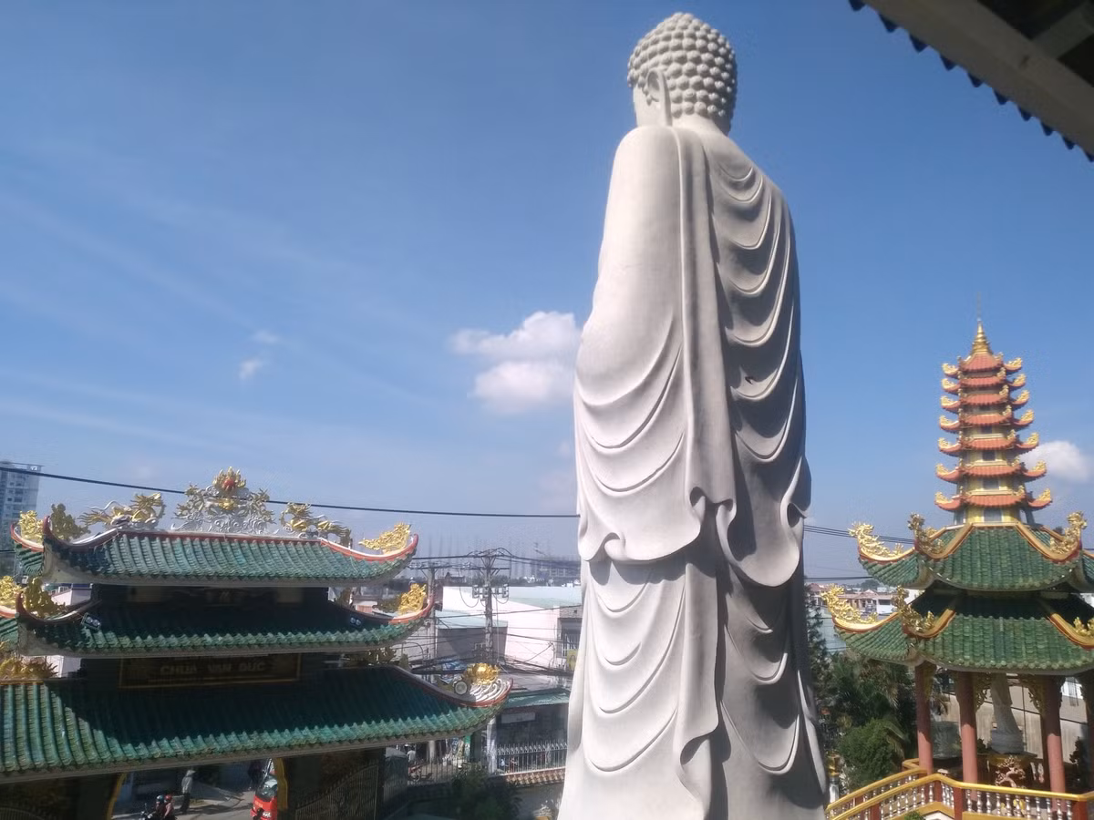 Trước tòa chánh điện là bức tượng Bổn Sư đang đứng uy nghi trên đài sen với chiều cao hơn 10m. 