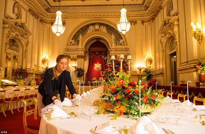 Martha Lowry Corry, nhân viên phục vụ, đang chỉnh lại các đồ vật trên bàn tiệc trước khi Royal Welcome bắt đầu. Đội phục vụ sẽ đặt 1.104 ly thủy tinh lên các bàn tiệc. Mỗi vị khách sẽ có 6 ly để đựng nước, rượu vang trắng, vang đỏ... Ảnh: PA