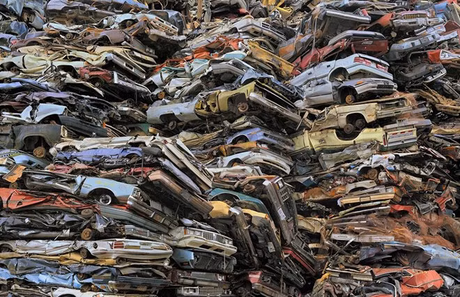 Những chiếc ô tô đã qua sử dụng bị đập bẹp và xếp chồng lên nhau trong khu bãi rác ở Tacoma, Washington. Người ta sẽ tận dụng kim loại từ những chiếc xe hỏng để tái phục vụ quá trình sản xuất.