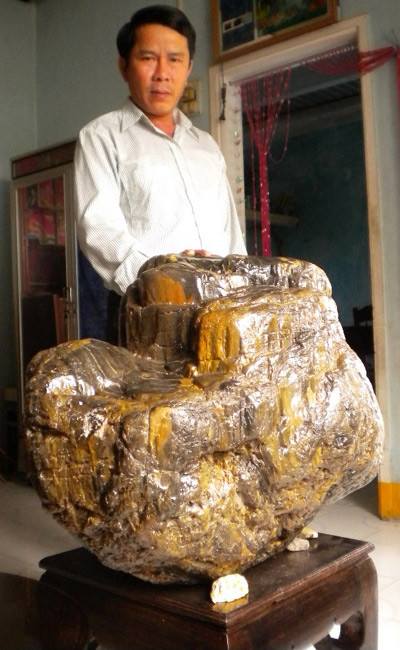 Trong một lần đào cát làm đường nằm dưới lòng đất có độ sâu hơn 5m ở sông Vân Canh (Bình Định), ông Lê Văn Bảy tình cờ phát hiện gốc cây gỗ hóa thạch này cao 51cm, đường kính chỗ lớn nhất lên tới 67cm, nơi nhỏ nhất là 52cm, có khối lượng nặng xấp xỉ 200 kg. Ảnh: Quân đội nhân dân Online.