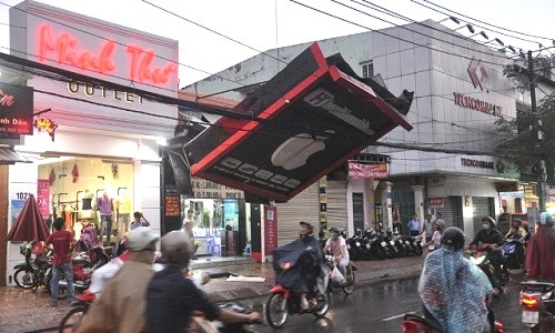 Thoạt nhìn tưởng như biển quảng cáo đu dây điện chơi ngông, thực chất đây là hậu quả sau một cơn bão khiến tấm biển bị đổ, vướng vào dây điện khá nguy hiểm.