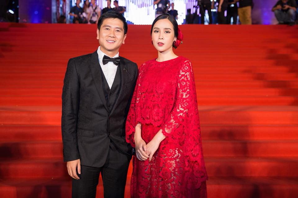 Hồ Hoài Anh lịch thiệp với vest đen, sánh bước bên Lưu Hương Giang lộng lẫy trong chiếc đầm đỏ nổi bật.