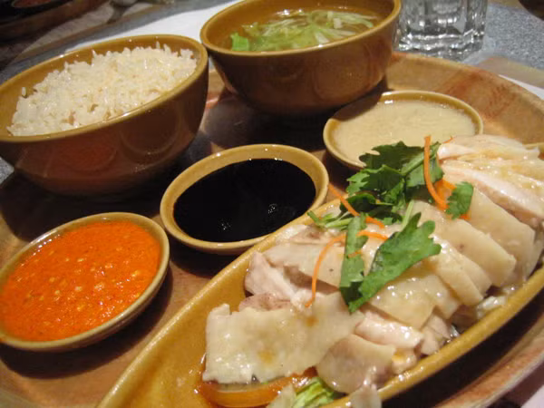 Cơm gà Hải Nam: Món ăn này khá phổ biến ở Singapore. Đĩa cơm dẻo được nấy bằng nước luộc gà béo ngậy được ăn kèm với những miếng thịt gà chấm tương ớt chắc chắn sẽ kích thích tiêu hóa của bất kì một thực khách nào.