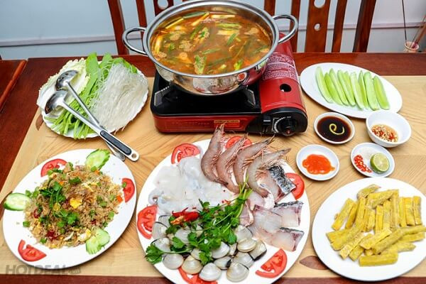 Bật bếp, đun nồi nước dùng cho sôi lại rồi sau đó thả ngao, thịt gà, ngô ngọt, ít nấm vào trước. Khi các nguyên liệu chín rồi mới nhúng rau và các thực phẩm còn lại.