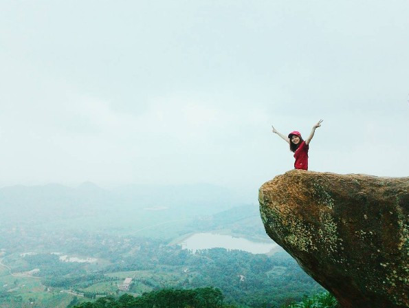 Cách trung tâm Hà Nội chừng 10 km, mỏm đá ở xã Tiến Xuân, huyện Thạch Thất cũng từng làm mưa làm gió dân phượt. Để đến được mỏm đá, bạn phải leo đồi khoảng 1 giờ. Trên ảnh check-in, địa điểm này tạo cảm giác chênh vênh. Trong thực tế, mỏm đá chỉ nhô ra một chút và cách mặt đất khoảng 5 m. Vì nằm ở địa hình dốc, du khách nên cẩn thận khi chụp hình tại mỏm đá này. Ảnh: phuongnt93, kien nguyen.