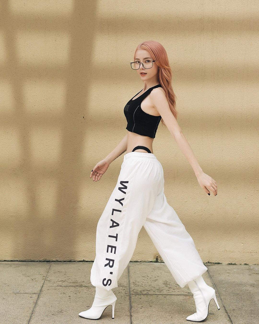 Trong tủ đồ của Kim Thành cũng có những trang phục năng động như jogger. Cô phối chiếc quần này với áo croptop hai dây màu đen cùng boots cổ thấp cao gót màu trắng.