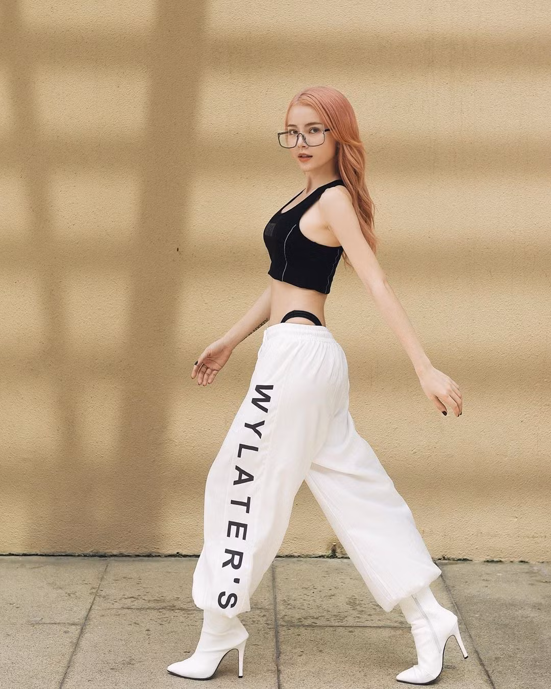Trong tủ đồ của Kim Thành cũng có những trang phục năng động như jogger. Cô phối chiếc quần này với áo croptop hai dây màu đen cùng boots cổ thấp cao gót màu trắng.