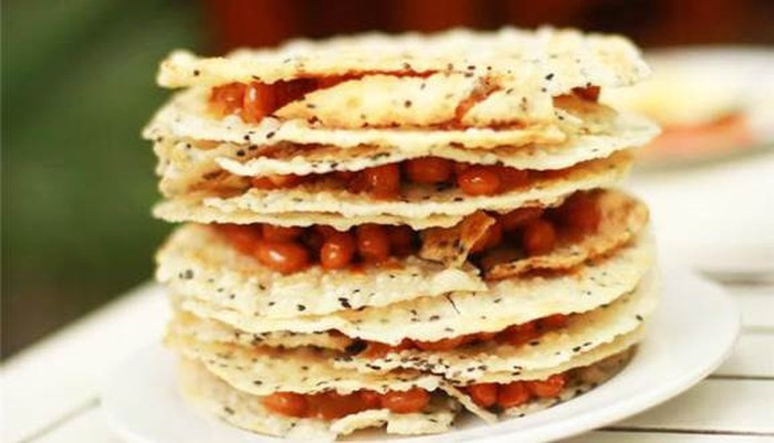 Kẹo cu đơ là đặc sản nổi tiếng của Hà Tĩnh có hình tròn như chiếc gương. Nhìn bề ngoài thô ráp và sần sùi nhưng cu đơ lại rất thơm, có vị đậm đà của mật mía, thơm cay cay của gừng tươi, cái giòn tan của lạc và bánh tráng vừng. Ảnh: Foody.