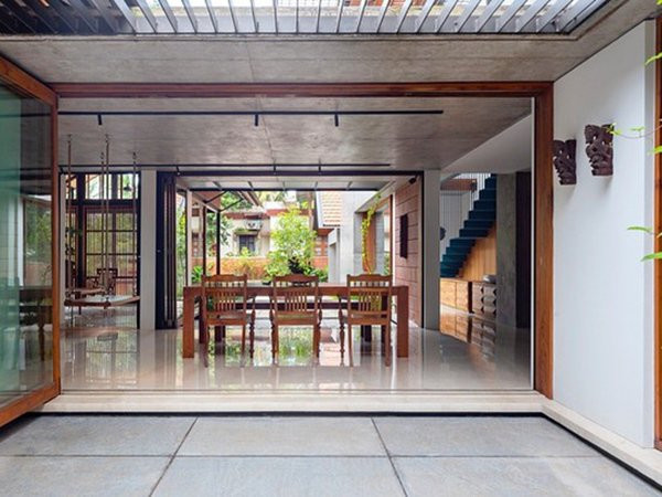 Một chiếc cửa bằng kính có thể gấp lại, mở ra không gian rộng cho căn nhà.