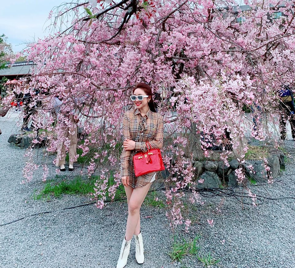 Bà chủ thẩm mỹ viện trông cực sang chảnh khi phối váy kẻ với túi xách đỏ và kính trắng.