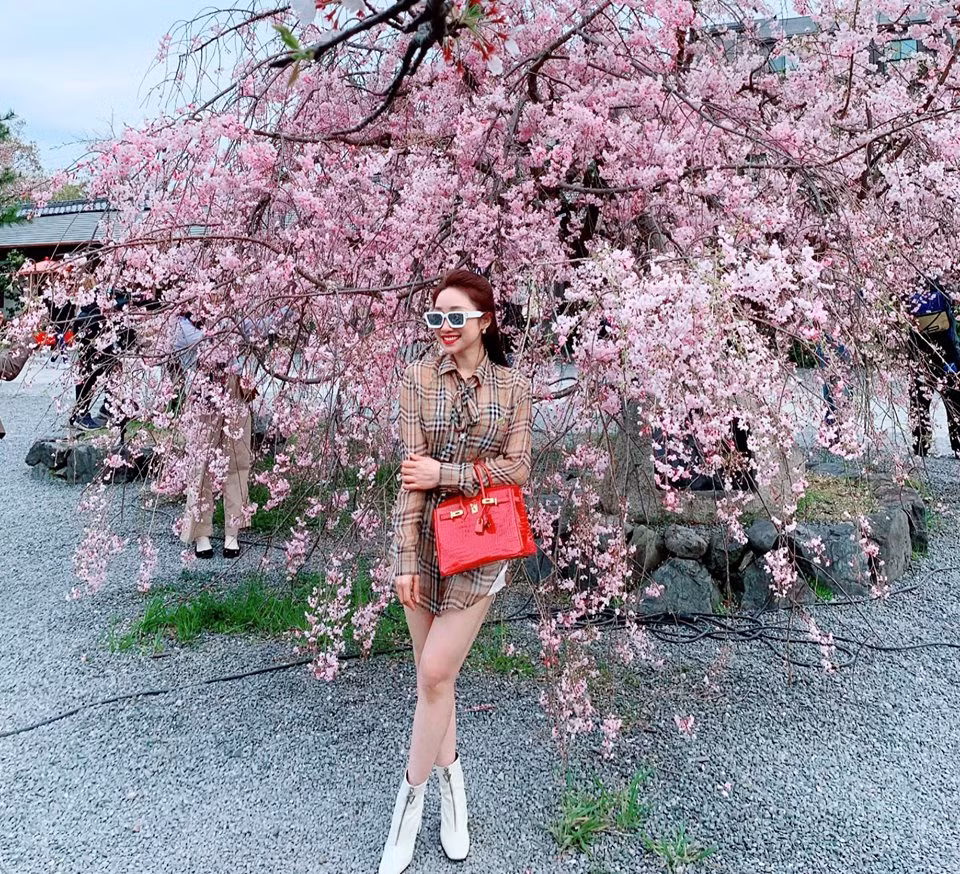 Bà chủ thẩm mỹ viện trông cực sang chảnh khi phối váy kẻ với túi xách đỏ và kính trắng.