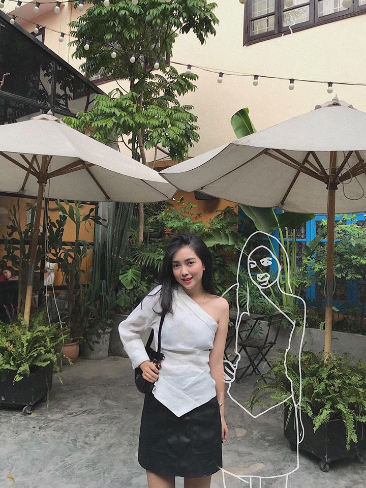 Áo lệch vai trắng phối với chân váy đen cực sành điệu.