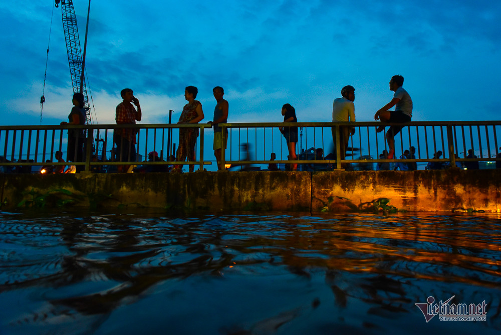 Người dân đứng trên cầu Ngang nhìn triều cường lên cao.