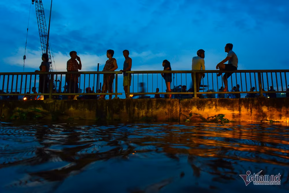 Người dân đứng trên cầu Ngang nhìn triều cường lên cao.