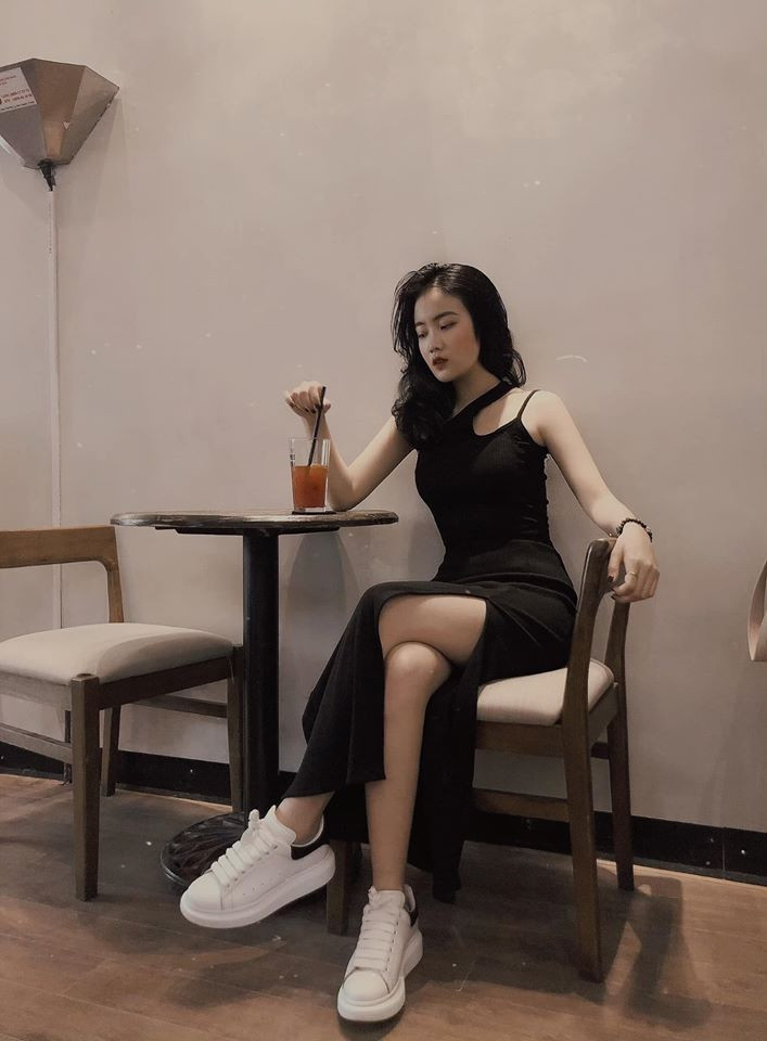 Hoàng Anh diện váy đen có đường cắt xẻ táo bạo, phối với giày thể thao năng động, trẻ trung.