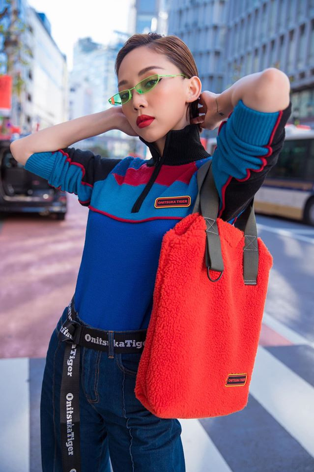 Nữ ca sĩ Tóc Tiên chọn một chiếc áo cổ cao thời thượng phối với quần jean và chiếc túi xách đỏ cá tính xuống phố.