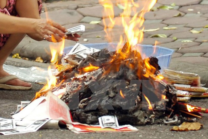 Trong lễ hóa vàng, người dân làm mâm cơm cúng gia tiên rồi đem vàng mã đã cúng trong 3 ngày Tết ra hóa. Sau khi hóa vàng, người ta vẩy rượu cúng lên tro vì cho rằng như thế các cụ ở cõi thiêng mới nhận và tiêu được tiền vàng. Ảnh: Internet. Video "Chế biến món ngon từ nấm đông cô". Nguồn: VTC.