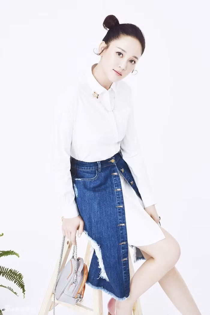 Áo sơ mi dáng dài mặc bên trong chân váy jean là cách phối mới mẻ và trẻ trung.