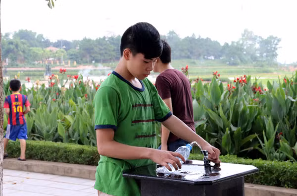 Người dân sử dụng nước sạch tại vòi. Ảnh: Vĩnh Phúc.