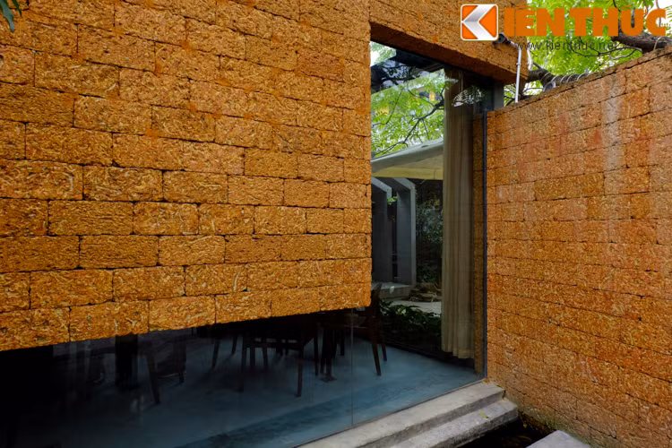 Thay vì thiết kế các mảng tường hoàn toàn bằng đá ong, các kiến trúc sư đã đưa thêm các ô cửa kính, điều này khiến ranh giới giữa không gian bên trong và bên ngoài công trình, giữa bên trên mái và dưới mặt đất dường như bị xóa nhòa. Tính hiện đại và truyền thống hài hòa trong trong thiết kế. Các ô kính cũng giúp lấy sáng tự nhiên cho không gian bên trong nhà.