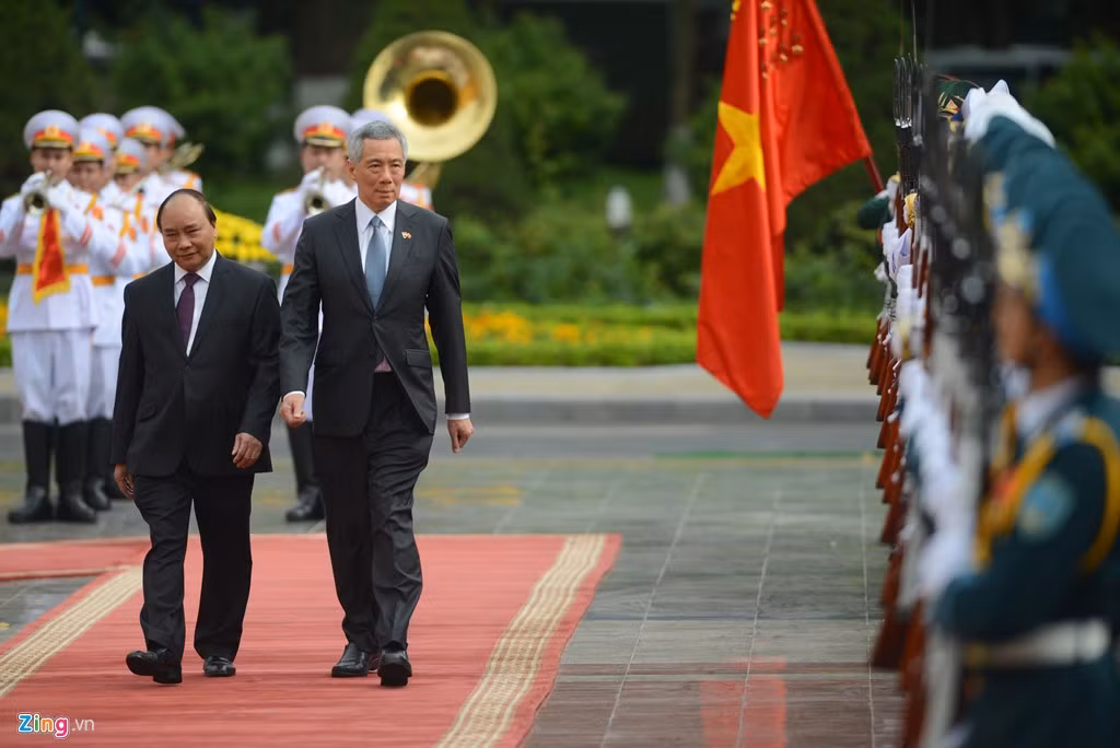 Đây là lần thứ ba ông Lý Hiển Long thăm chính thức Việt Nam trên cương vị thủ tướng, sau các chuyến công du năm 2010 và 2013. Trong khuôn khổ chuyến thăm lần này, hai bên trao đổi các phương hướng chiến lược, biện pháp cụ thể nhằm làm sâu sắc hơn quan hệ Đối tác chiến lược trong thời gian tới và ký kết 6 văn kiện trong lĩnh vực kinh tế. Ảnh chụp Thủ tướng Nguyễn Xuân Phúc và Thủ tướng Lý Hiển Long trong lễ đón chính thức sáng 23/3.