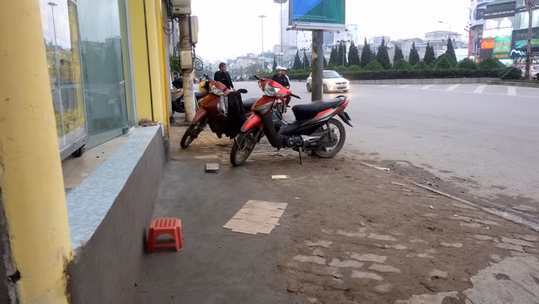 Để tiện di chuyển, một hộ kinh doanh dùng ghế nhựa để bước vào nhà. Hình ảnh quen thuộc trên vỉa hè của con phố Xã Đàn sau chiến dịch giành lại vỉa hè cho người đi bộ triển khai.