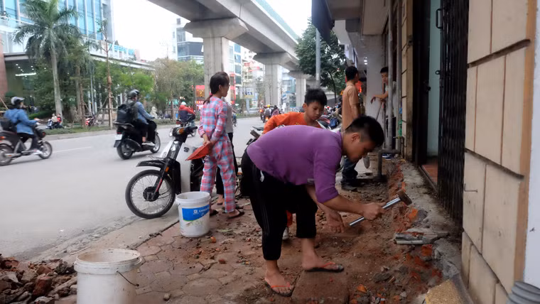 Nhiều người dân tại Hoàng Cầu bắt tay vào việc chỉnh trang lại phần vỉa hè, bậc thềm còn lại trước cửa nhà.