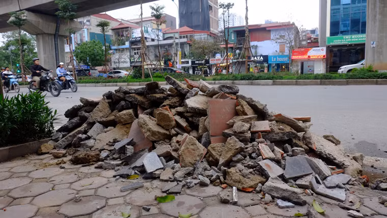 Gạch đá chất đống bên vỉa hè, tràn xuống lòng đường gây mất mỹ quan đô thị và ảnh hưởng đến giao thông.