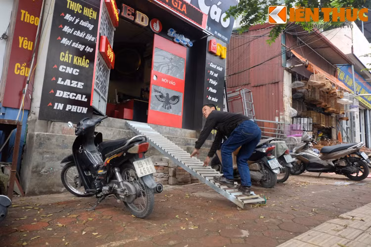 Cùng chung "thảm cảnh" phải leo trèo vào nhà sau khi bậc tam cấp trước cửa hàng bị phá dỡ, chủ cửa hàng quảng cáo trên đường Hoàng Hoa Thám đã phải làm một chiếc thang sắt để vào nhà.