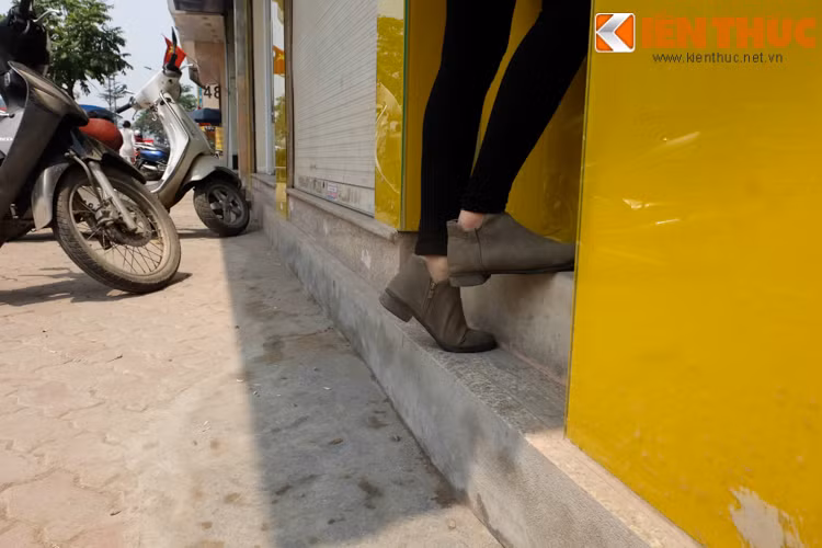 Không còn cách nào để khắc phục tình trạng oái oăm này, cô gái phải kiễng chân để rút tiền trên cây ATM.