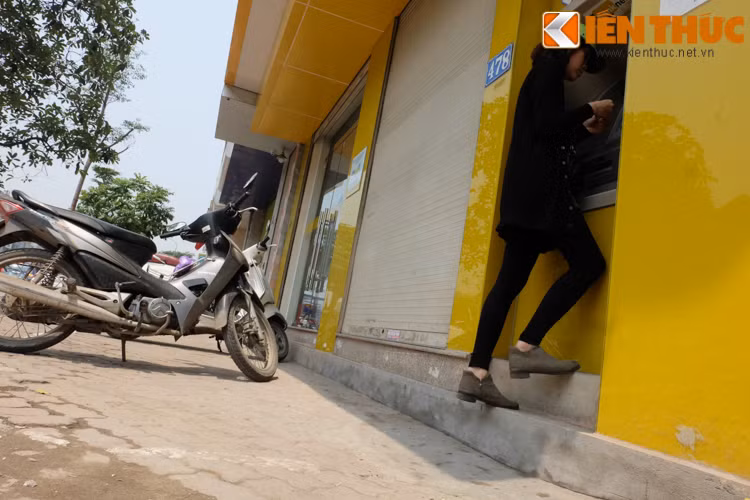 Cô gái này chỉ có thể đứng trên chiếc bậc rộng khoảng 20cm để rút tiền.