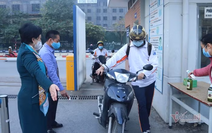 Tại Trường THPT Chuyên Hà Nội học sinh cũng được đo thân nhiệt và khử khuẩn tại khu vực cổng trường trước khi lên lớp. (Ảnh: Vietnamnet)