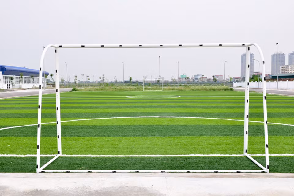 Cạnh nhà thi đấu đa năng là sân bóng cỏ nhân tạo xanh mướt.