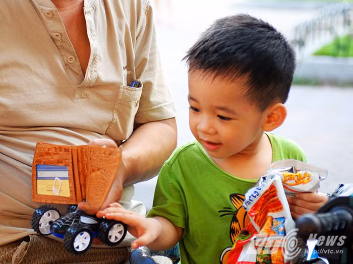 Vẻ hào hứng của một em nhỏ khi được cha mẹ mua cho món đồ chơi thú vị từ sạp hàng rong của David.