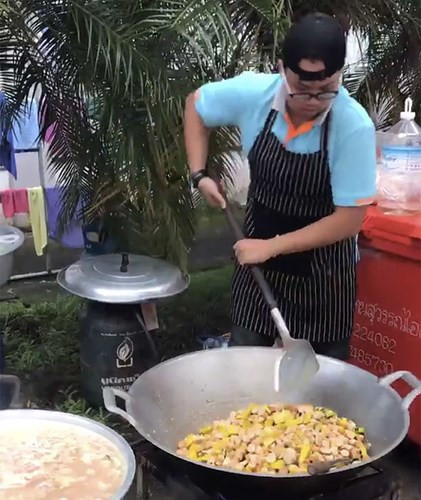 Một tình nguyện viên đang nấu cơm cho đội cứu hộ. Ảnh: Express.