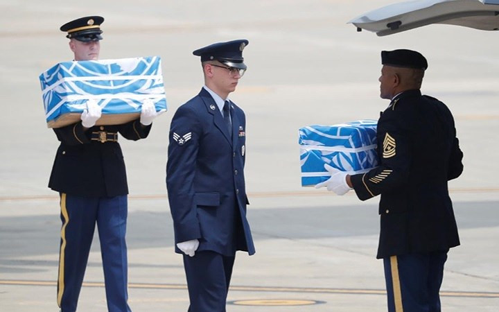 Các bộ hài cốt được bọc trong màu cờ xanh của Liên Hợp Quốc.