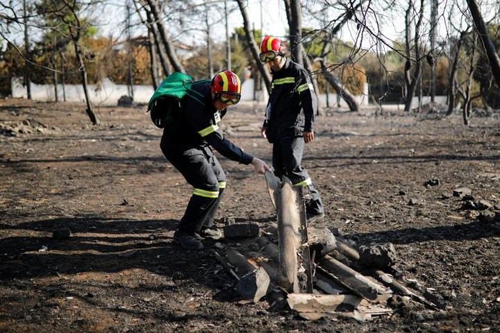 Các thành viên của lực lượng cứu hộ tìm kiếm tại làng Mati, gần thủ đô Athens.