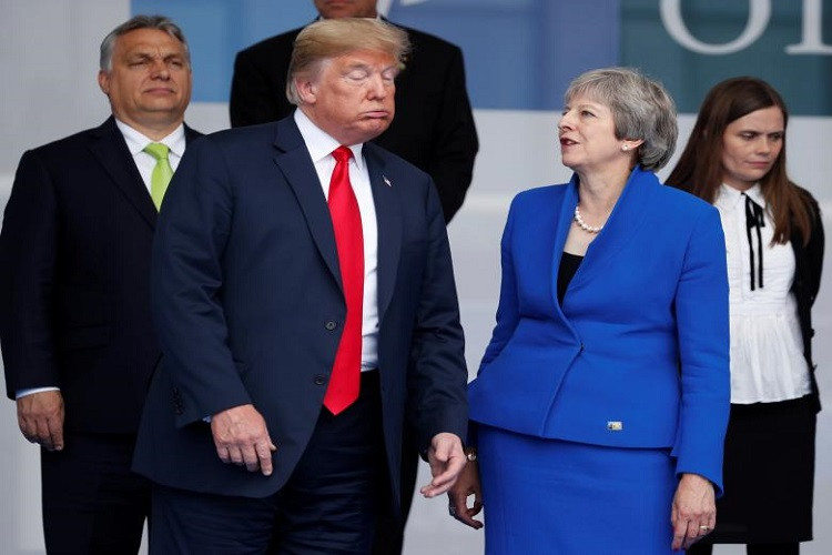 Biểu cảm lạ của Tổng thống Donald Trump khi đang trao đổi với Thủ tướng Anh Theresa May bên thềm hội nghị. Ảnh: Reuters.
