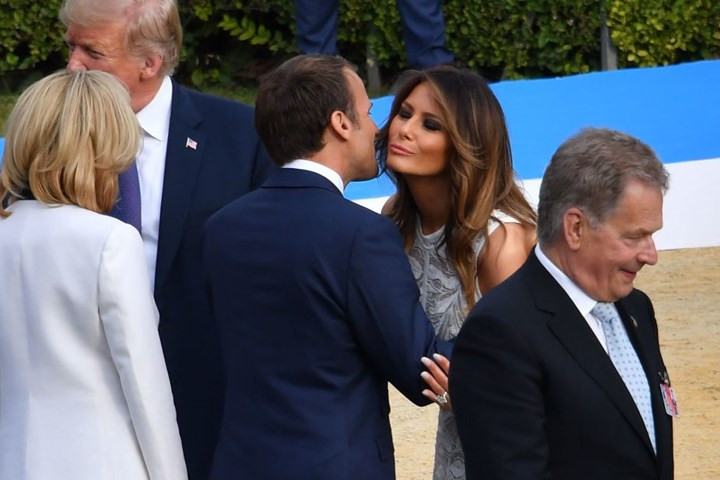 Tổng thống Pháp Macron hôn chào đệ nhất phu nhân Melania Trump trước khi chụp ảnh lưu niệm tập thể.