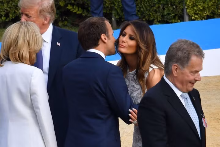 Tổng thống Pháp Macron hôn chào đệ nhất phu nhân Melania Trump trước khi chụp ảnh lưu niệm tập thể.