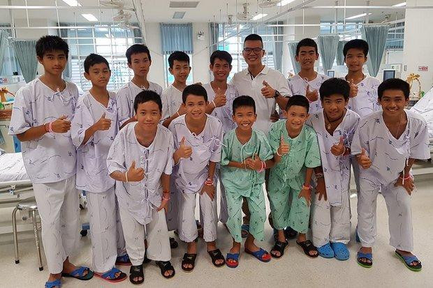 12 thành viên đội bóng "Lợn hoang" cùng huấn luyện viên Ekapol Chantawon (trái) và bác sĩ quân y Col Pak Loharachun (hàng sau, thứ ba từ phải sang) người ở lại với họ sau cùng trong chiến dịch giải cứu kéo dài từ 8/7-10/7. Ảnh: Bangkok Post.